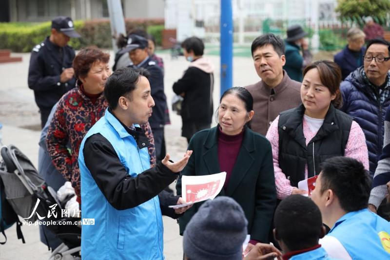 4月12日，“老外”网格员小龙在镇江新区丁卯街道武将社区宣传接种疫苗事宜。